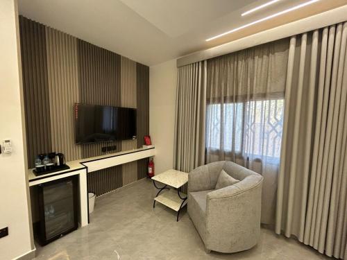 a living room with a chair and a television at قمرة قباء Quba moon5 in Al Madinah