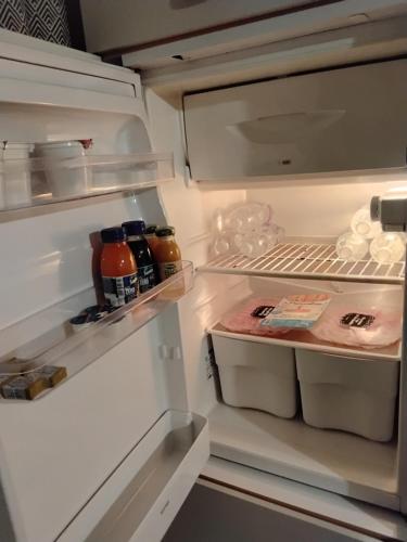 an open refrigerator with its door open and food inside at Alpine's Apartment in Arnoldstein
