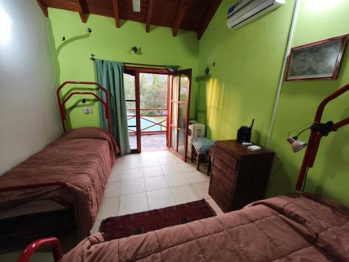 a bedroom with two beds in a room with green walls at Casa de Nancy y Carlos in Juana Koslay 