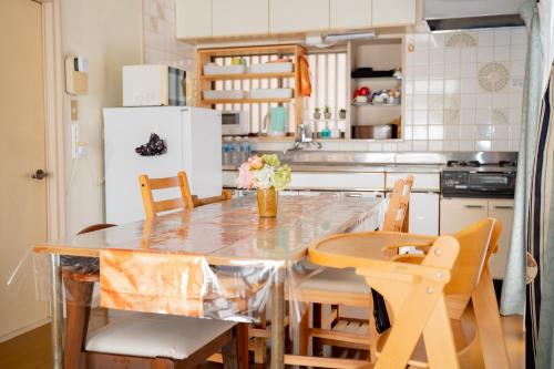eine Küche mit Tisch und Stühlen und einem Kühlschrank in der Unterkunft Ai dear KAWAGOE in Kawagoe