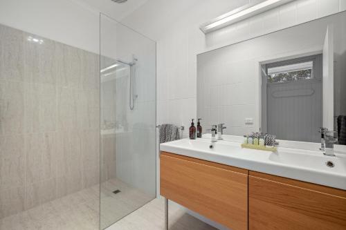 a white bathroom with a sink and a shower at Waterfront Seabreeze Cowes in Cowes