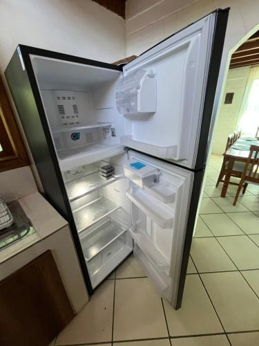 Un refrigerador vacío con la puerta abierta en una cocina. en Casa de Emmita, en Puyo