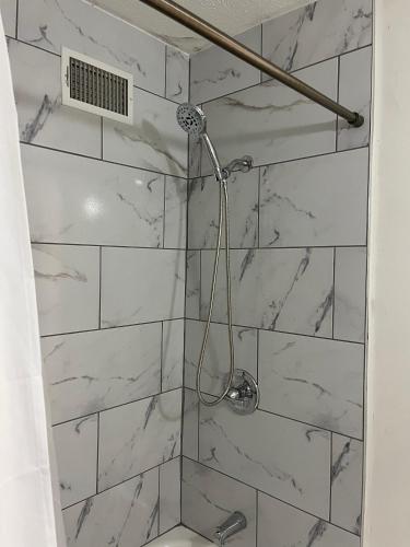 a bathroom with a shower with white marble tiles at Oilgate at Parkgate in Akron