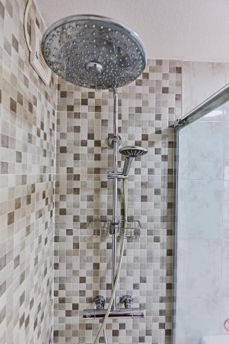 a shower with a shower head in a bathroom at Casa Dorotea in Playa del Cura