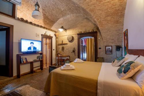 a bedroom with a large bed and a tv at L'Alcova dei Grifoni in Ascoli Satriano
