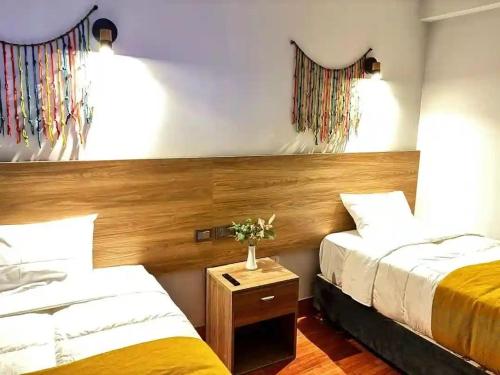 een slaapkamer met twee bedden en een tafel met bloemen bij Marvelous Plaza in Cuzco