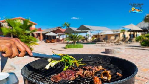 a person is cooking food on a grill at 3 bedroom Beach side home away from home in San Felipe