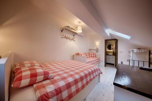 a attic bedroom with two beds and a refrigerator at RIVA SUITE 2 in Komiža