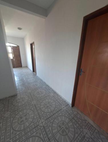 een lege kamer met een deur en een tegelvloer bij Pousada em Ilhéus in Ilhéus