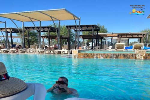a person in the water at a swimming pool at Casa Desert Rose - Gated Community San Felipe Vacation Rental Home in Playa Hawaii