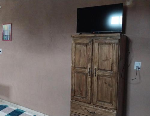 a flat screen tv on top of a wooden cabinet at El Shaddai I in Santiago del Estero