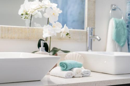 a bathroom with two sinks and towels on a counter at Ocean Pearl Hudson Beach in Hudson