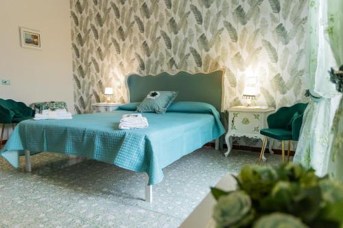 1 dormitorio con 1 cama azul y 2 sillas en Fabiola Guest House, en Pompeya