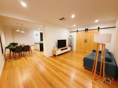 un salon avec un canapé et une table dans l'établissement Modern 2 bedroom home in burwood east, à Burwood East
