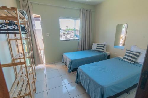 a room with two beds and a ladder in it at Casa de Verão, 04 quartos todos com ar condicionado, 03 banheiros, churrasqueira e piscina para relaxar in Pirapora