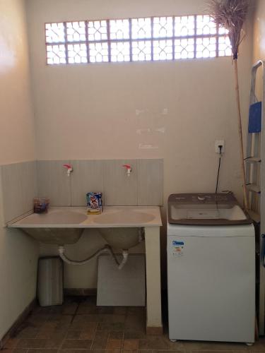 a bathroom with a sink and a small refrigerator at Casa de Verão, 04 quartos todos com ar condicionado, 03 banheiros, churrasqueira e piscina para relaxar in Pirapora