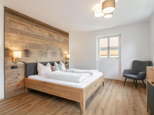 Un dormitorio con una cama con una pared de madera. en Hopfgarten Alpin Living Top 3, en Hopfgarten im Brixental