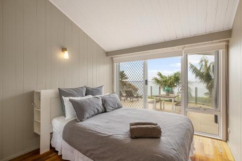 a bedroom with a large bed and a large window at Waterfront Seabreeze Cowes in Cowes