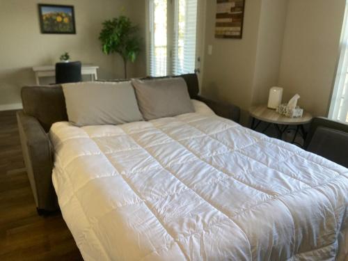 a large white bed in a room with a table at 20 Minutes to Skiing in Midvale