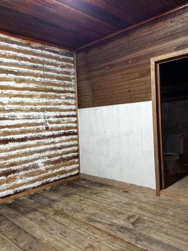 an empty room with a wooden wall at Aconchegante demais in Macapá