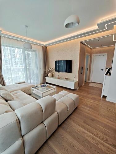 ベオグラードにあるBelgrade Waterfront Primestayの大きなソファと大きな鏡のあるリビングルーム