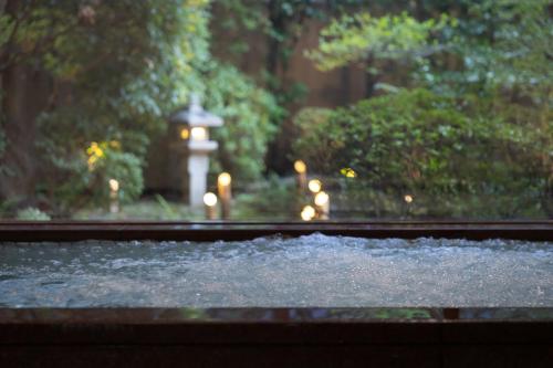 a view of a fountain with a building in the background at Loisir Hotel Classic Garden Kyoto Sanjo in Kyoto