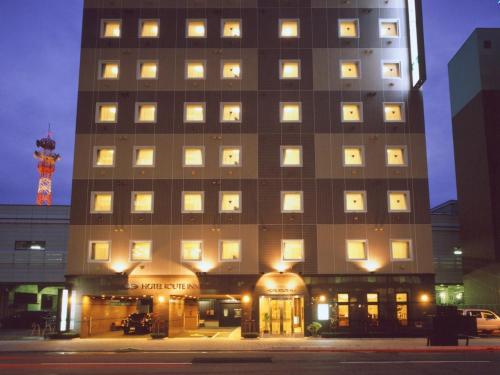 a tall building with lights in front of it at Hotel Route-Inn Fukui Ekimae in Fukui