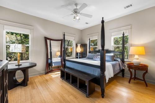 a bedroom with a bed and a desk and windows at Walk to Seaside and Beach in Santa Rosa Beach