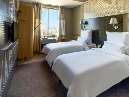 a hotel room with two beds and a television at ibis Jeddah City Center in Jeddah