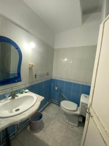 une salle de bain avec des toilettes blanches et un lavabo dans l'établissement Afif Apartment Djerba, à Al Maqārisah