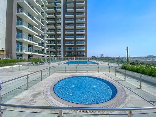 a large swimming pool in front of a building at Trinity Holiday Homes - Spacious Modern Living 1BR & 2BR Unique Apartment in Dubai
