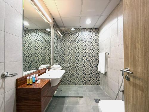 a bathroom with a sink and a mirror at Trinity Holiday Homes - Spacious Modern Living 1BR & 2BR Unique Apartment in Dubai