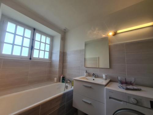 a bathroom with a tub and a sink and a bath tubermottermott at Maison plain-pied en Berry - Vue sur étang - Charges incluses - FR-1-591-748 in Migné