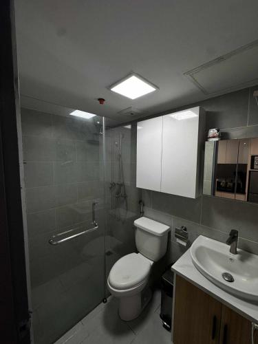a bathroom with a toilet and a sink at Cozy 1-BR Condo Unit in Mandaue City