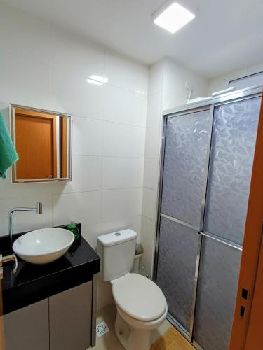 a bathroom with a toilet and a sink and a shower at Apartamento aconchegante in Maringá