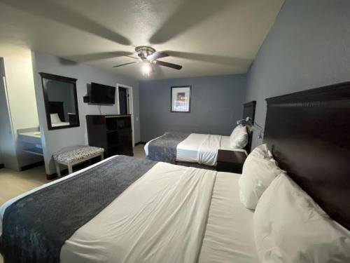 BerryvilleにあるAya's Blossoms Innのベッド2台、天井ファンが備わる客室です。