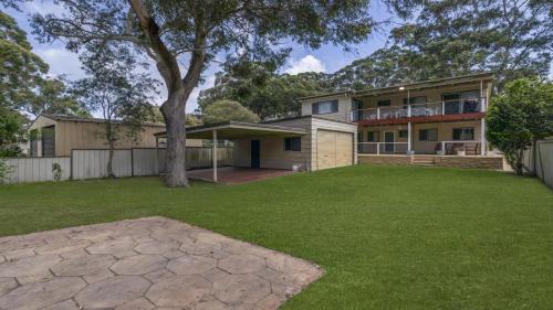 een huis met een boom in een tuin bij 30 Curlew Avenue Hawks Nest in Hawks Nest