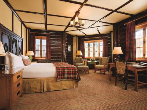 a hotel room with a bed and a desk and chairs at Fairmont Le Chateau Montebello in Montebello