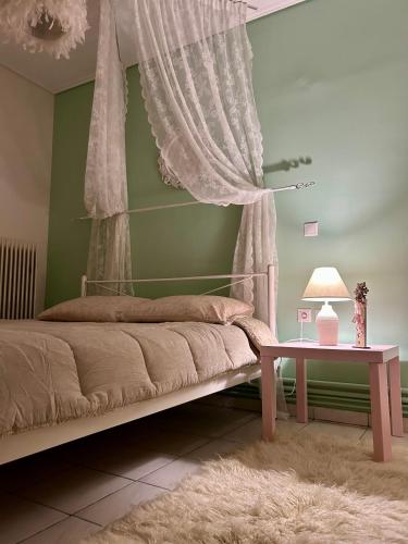 a bedroom with a bed with a table and curtains at Roseberry luxury apartment in Tríkala