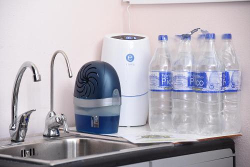 a kitchen counter with water bottles and a sink at Tabua Village Madeira Suite VIP in Ribeira Brava
