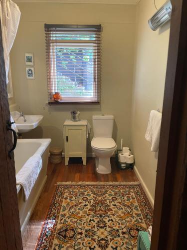 a bathroom with a tub and a toilet and a sink at Lear House Oamaru in Motungarara