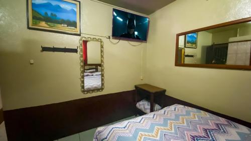 グアテマラシティにあるHotel Landivar Zona 7のベッドと鏡のある寝室