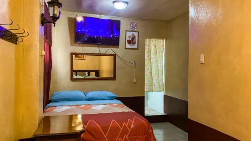 a room with a bed with a tv on the wall at Hotel Landivar Zona 7 in Guatemala