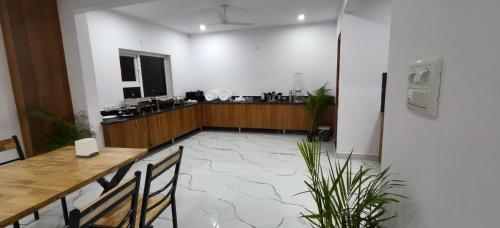 Habitación con mesa, sillas y barra. en Keerthis Comforts -Near Kempegowda international Airport Hotel, en Bangalore