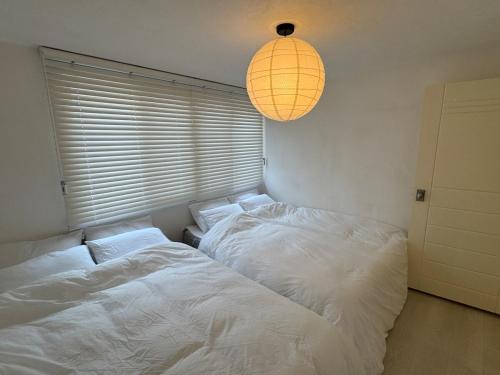 zwei Betten in einem Schlafzimmer mit einer Lampe in der Unterkunft NEW Gwangalli Beach 3-minute walk in Millak-tong