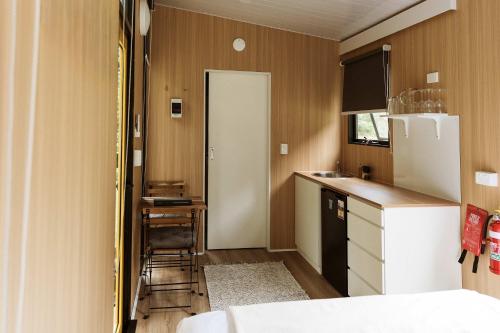 a small kitchen with a refrigerator and a table at Yarriabinni Escape 2 by Tiny Away in Stuarts Point