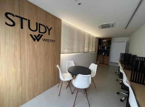a meeting room with a table and white chairs at West Fit Padrão 06 in Mossoró