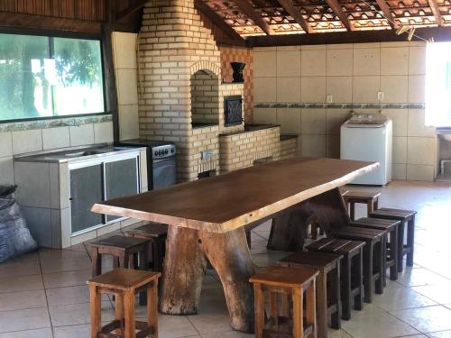 een grote houten tafel in een keuken met krukken bij Hotel fazenda Monte Verde in Uberlândia