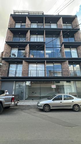 un coche aparcado delante de un gran edificio en Apartamento excelente ubicacion, en Sogamoso