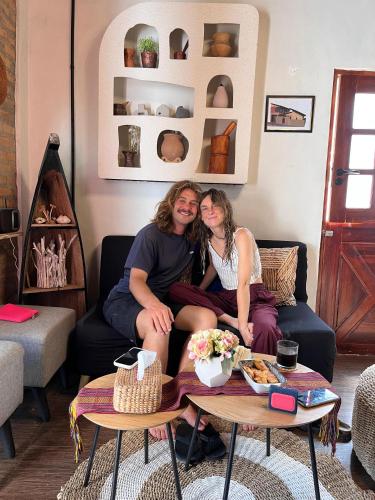 Due persone sedute su un divano in soggiorno di Loti Guest House a Kupang